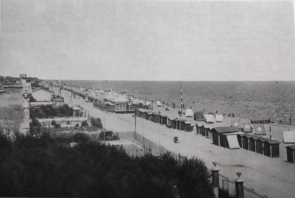L'arenile di Bellaria è formato di sabbia finissima… (Siamo all'altezza dell'attuale bagno 44. Sulla sinistra, l'elegante edificio con la caratteristica decorazione è il Circolo Bagnanti, oggi trasformato nell'hotel Giorgetti. Sulla spiaggia si vede la piattaforma Norge all'altezza dell'odierna via Adriatico. La foto è stata scattata dall'hotel Miramare)